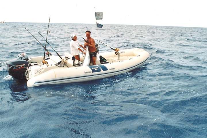 Il gommone Flyer 575 in mare, con due persone a bordo e una cattura sollevata